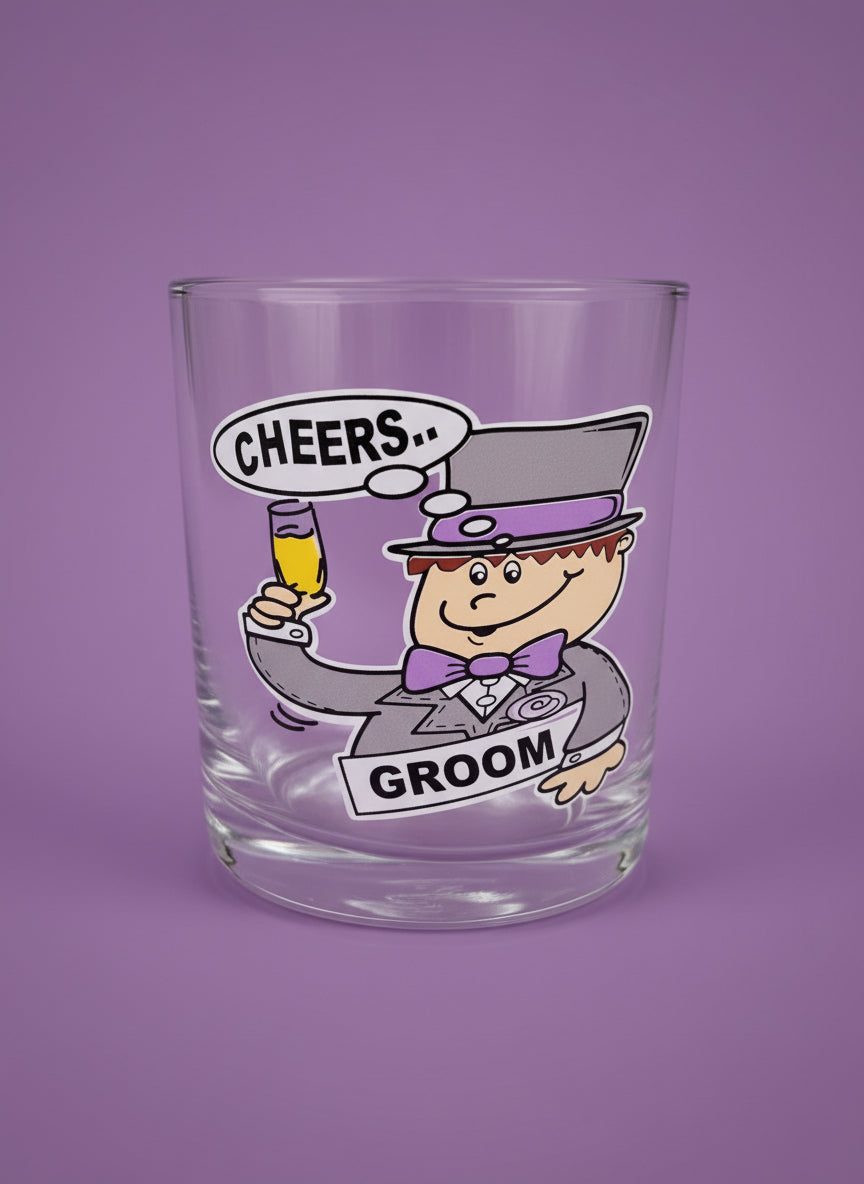 Clear shot glass with cartoon character and 'Cheers Groom' text on a purple background