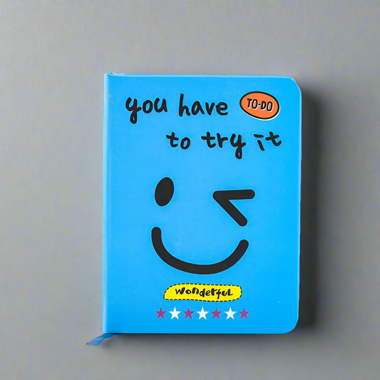 Blue notebook with smiley face and text on a gray background