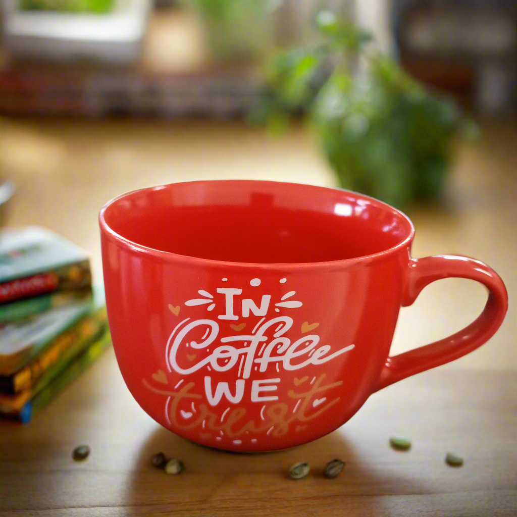 Red coffee mug with text on a wooden table.
