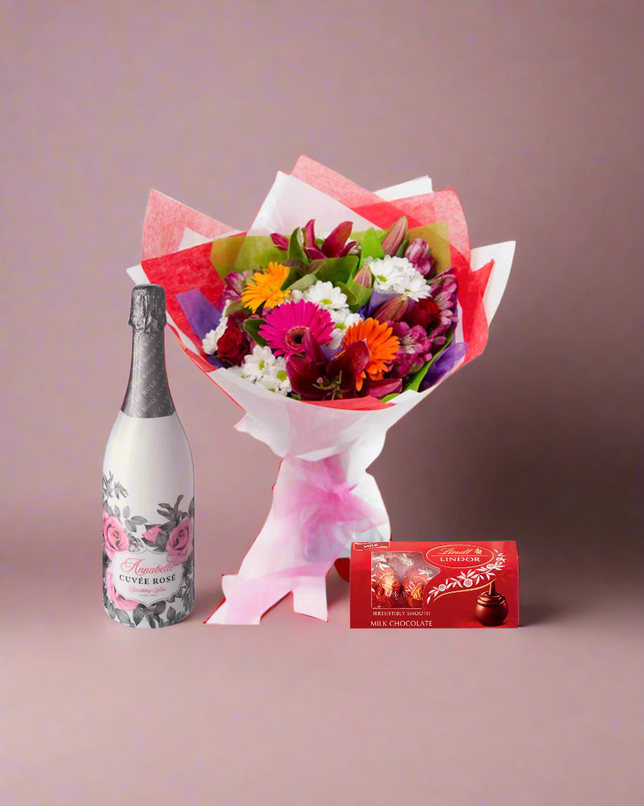 Bouquet of flowers with a bottle of champagne and chocolate bars on a white background