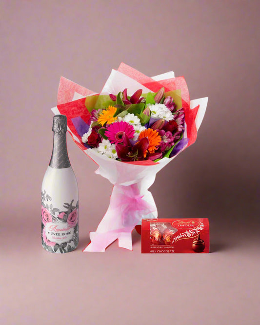 Bouquet of flowers with a bottle of champagne and chocolate bars on a white background