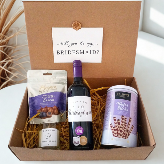 Gift box with wine, snacks, and a card asking 'will you be my bridesmaid?'